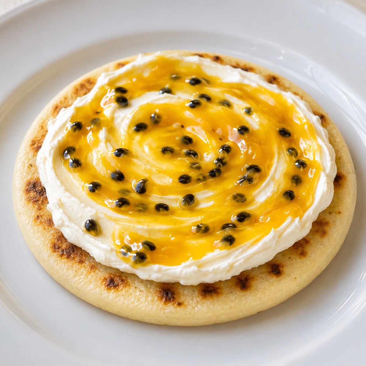Arepa spread with cream cheese and bright yellow passionfruit curd