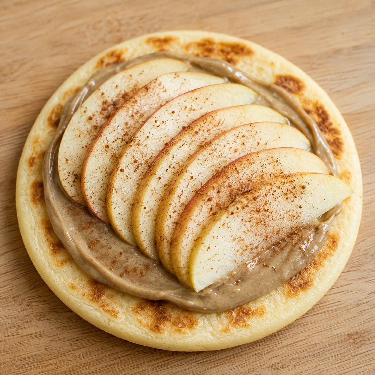 Arepa spread with sunflower seed butter, apple slices and cinnamon