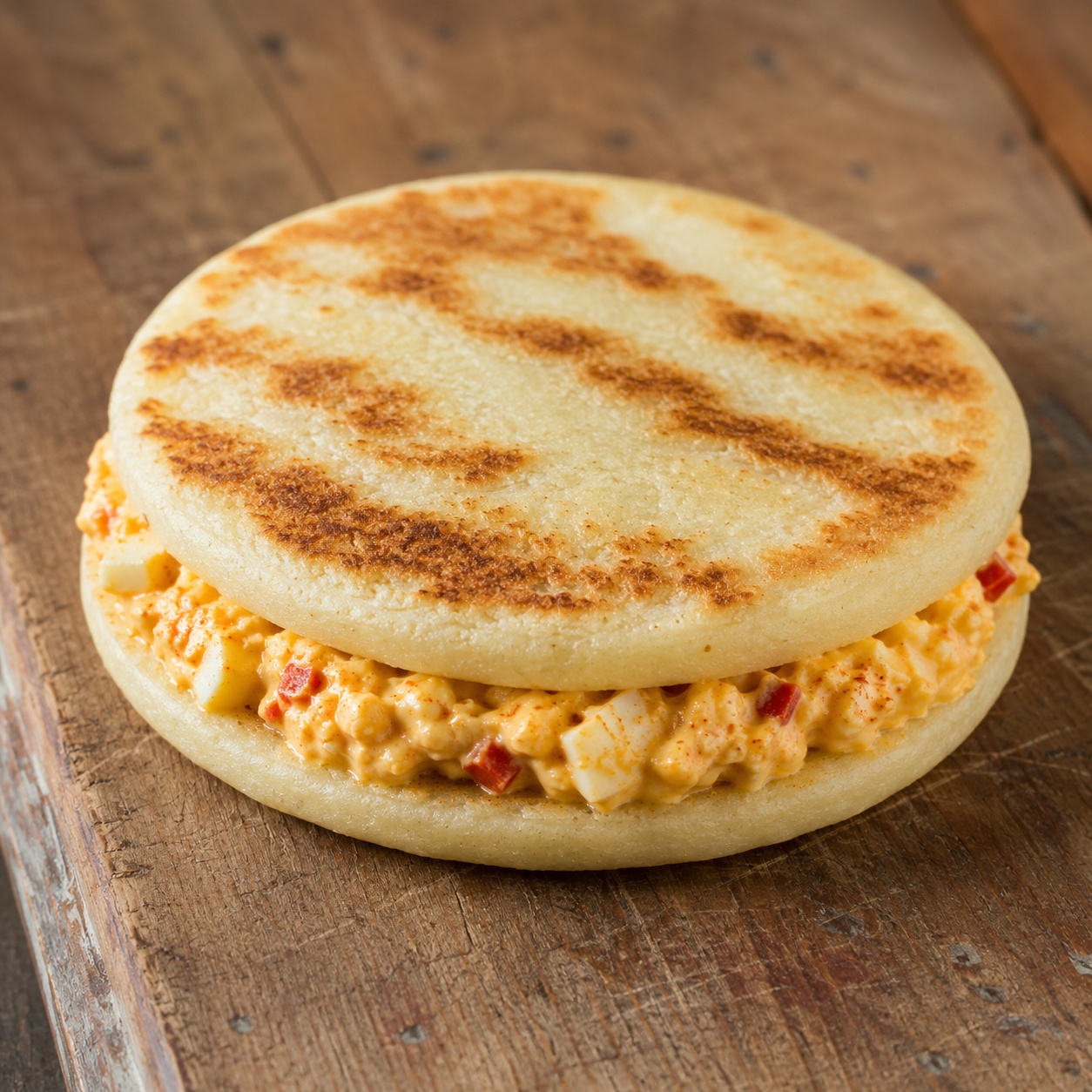 Two arepas sandwiched with smoked-paprika egg salad