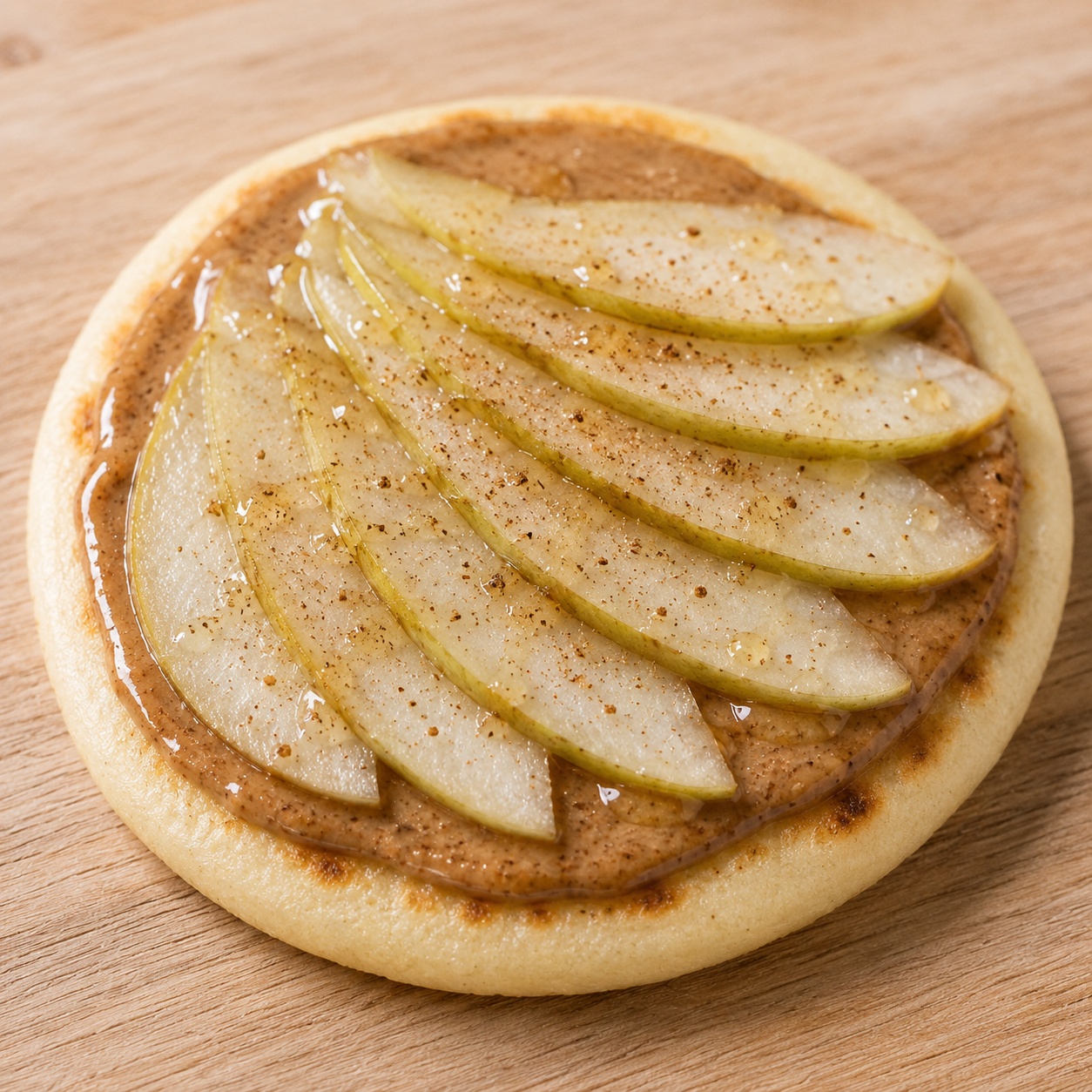Arepa spread with almond butter, fanned pear slices and a dusting of cardamom