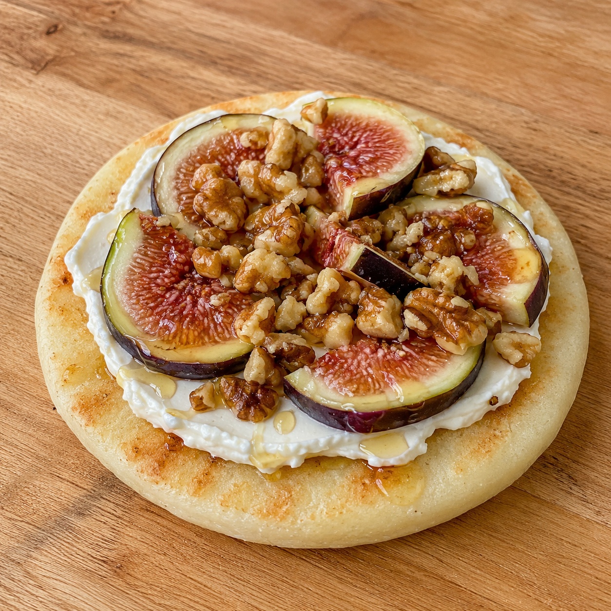 Arepa spread with cream cheese, sliced fresh figs and toasted walnuts