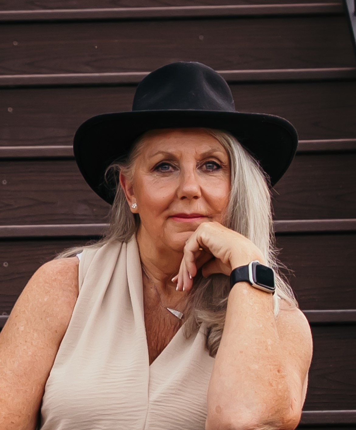 Shari Hudson in a black wide-brim hat, chin resting on her hand