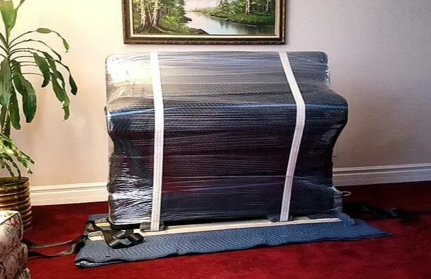 a Stack of moving boxes in a room with a light blue wall background