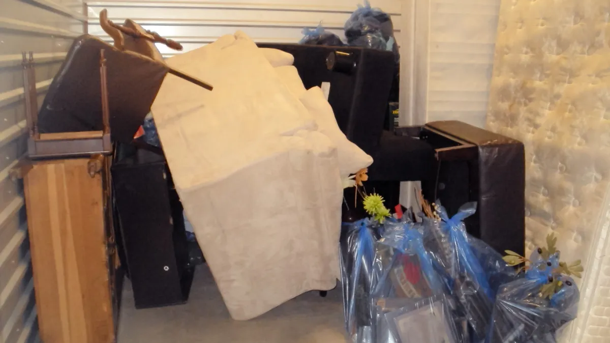 a Stack of moving boxes in a room with a light blue wall background