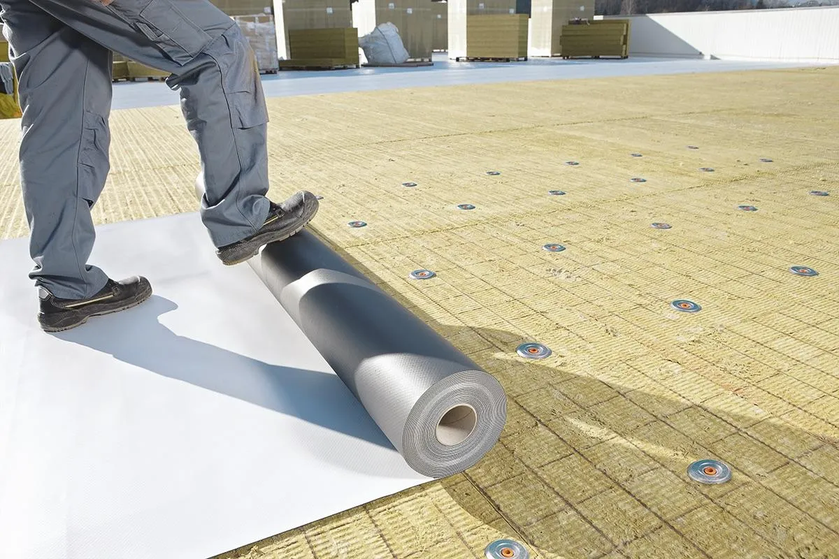 A suburban house nestled among trees on a grassy hill.