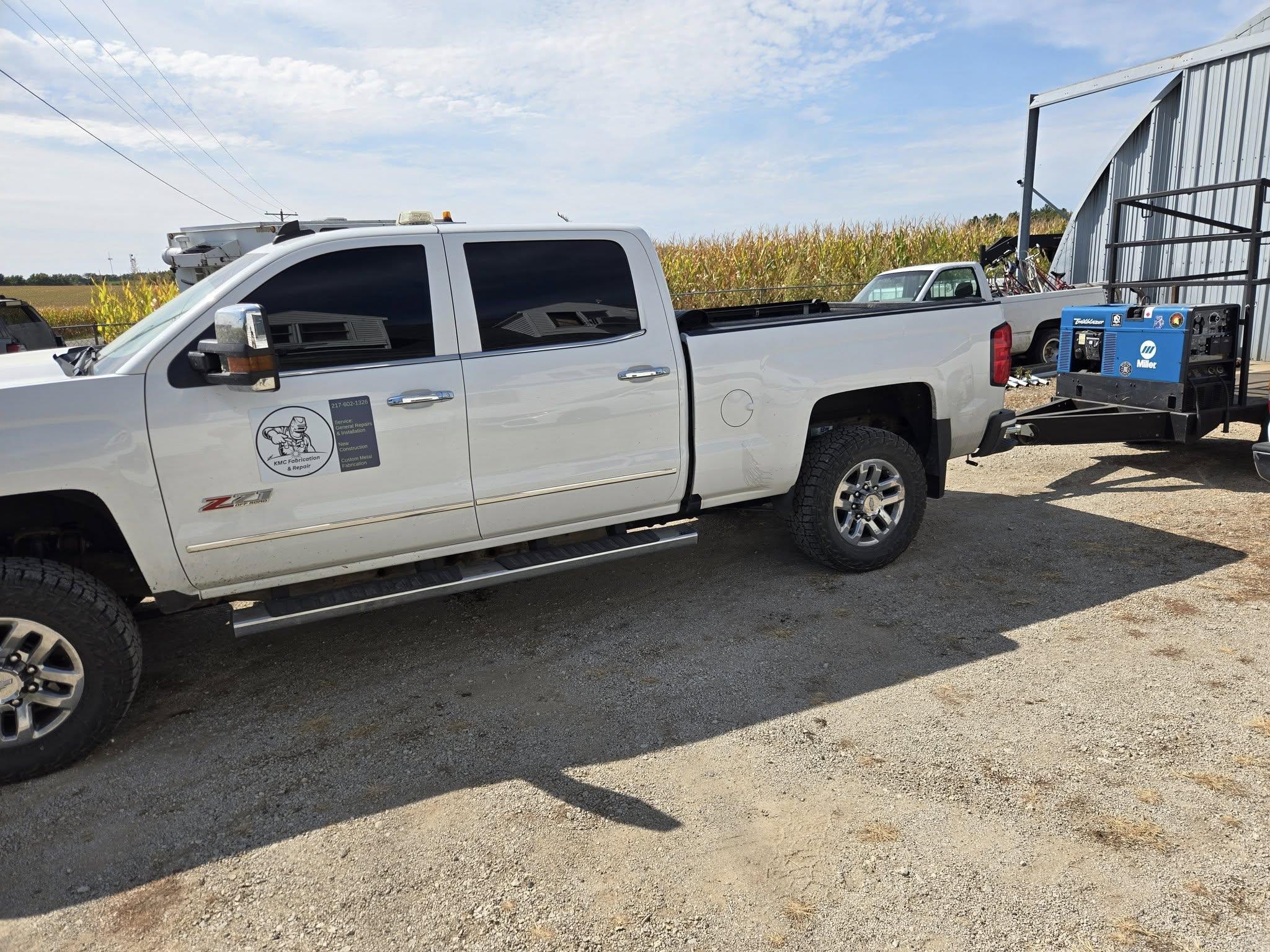 a man in a black jacket working on a piece of metal