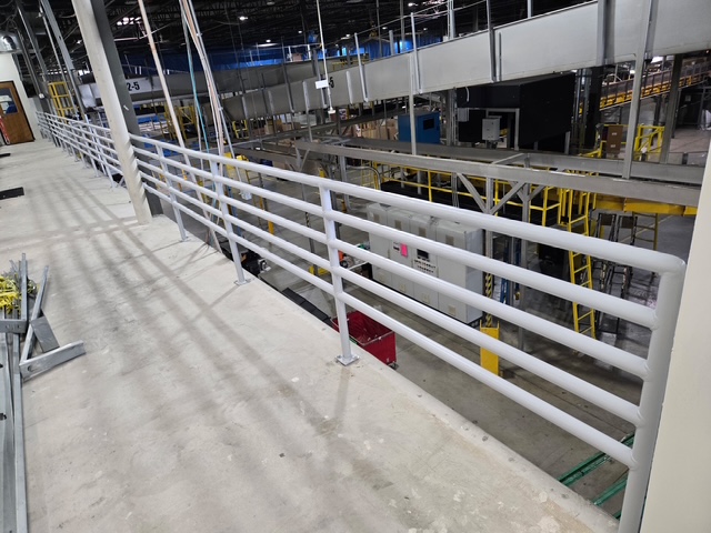 3D printer creating a red object with yellow filament.