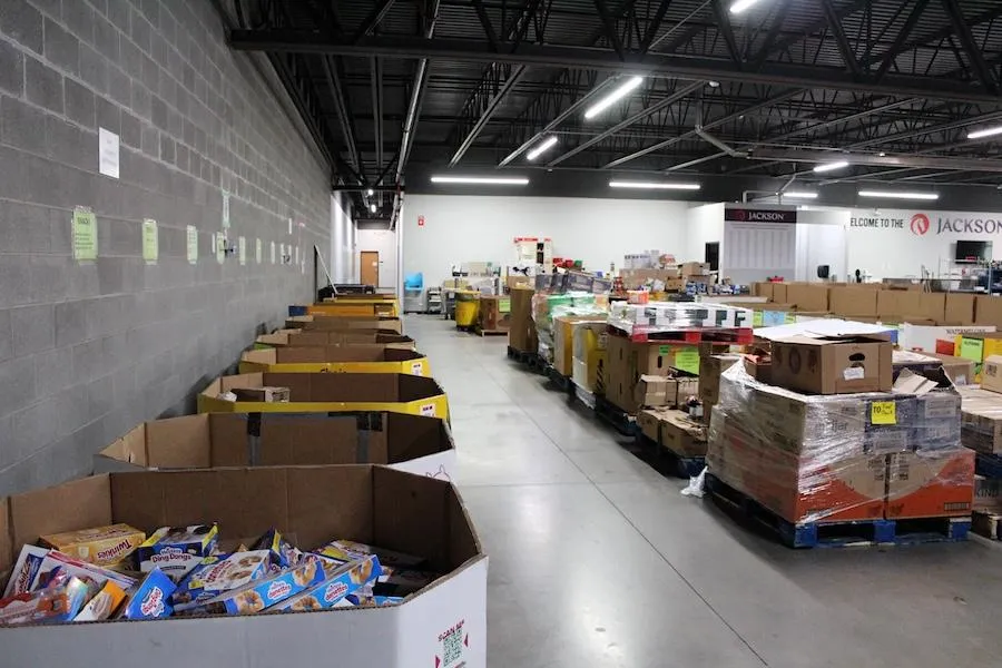 Red and white fire truck parked near modern stadium.