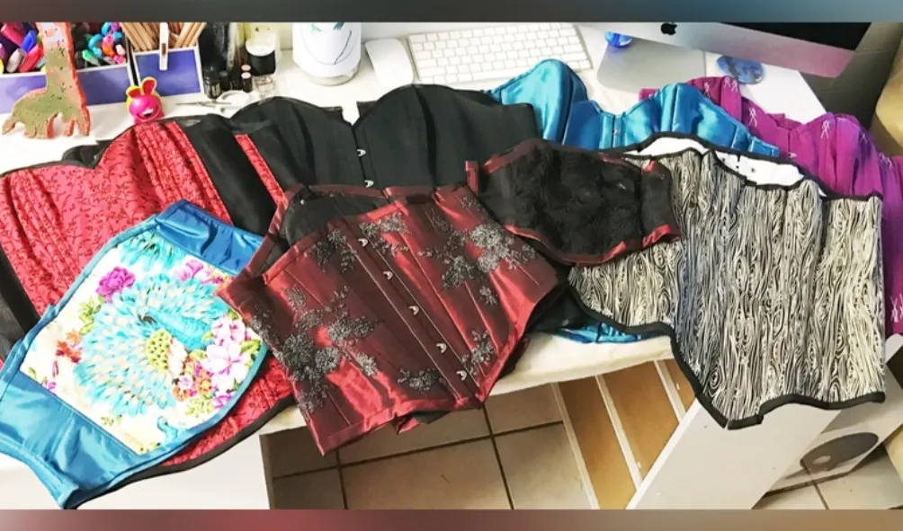 A pile of custom corsets made by Bespoke Stitchery 
