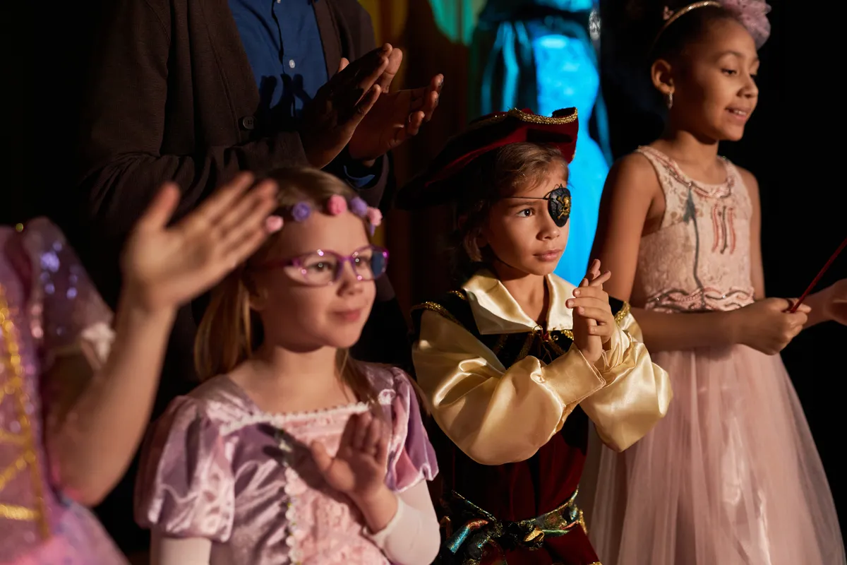How Kindergarten Teachers Can Use Role-Play for Language Practice - children-wearing-costumes-on-stage-clapping