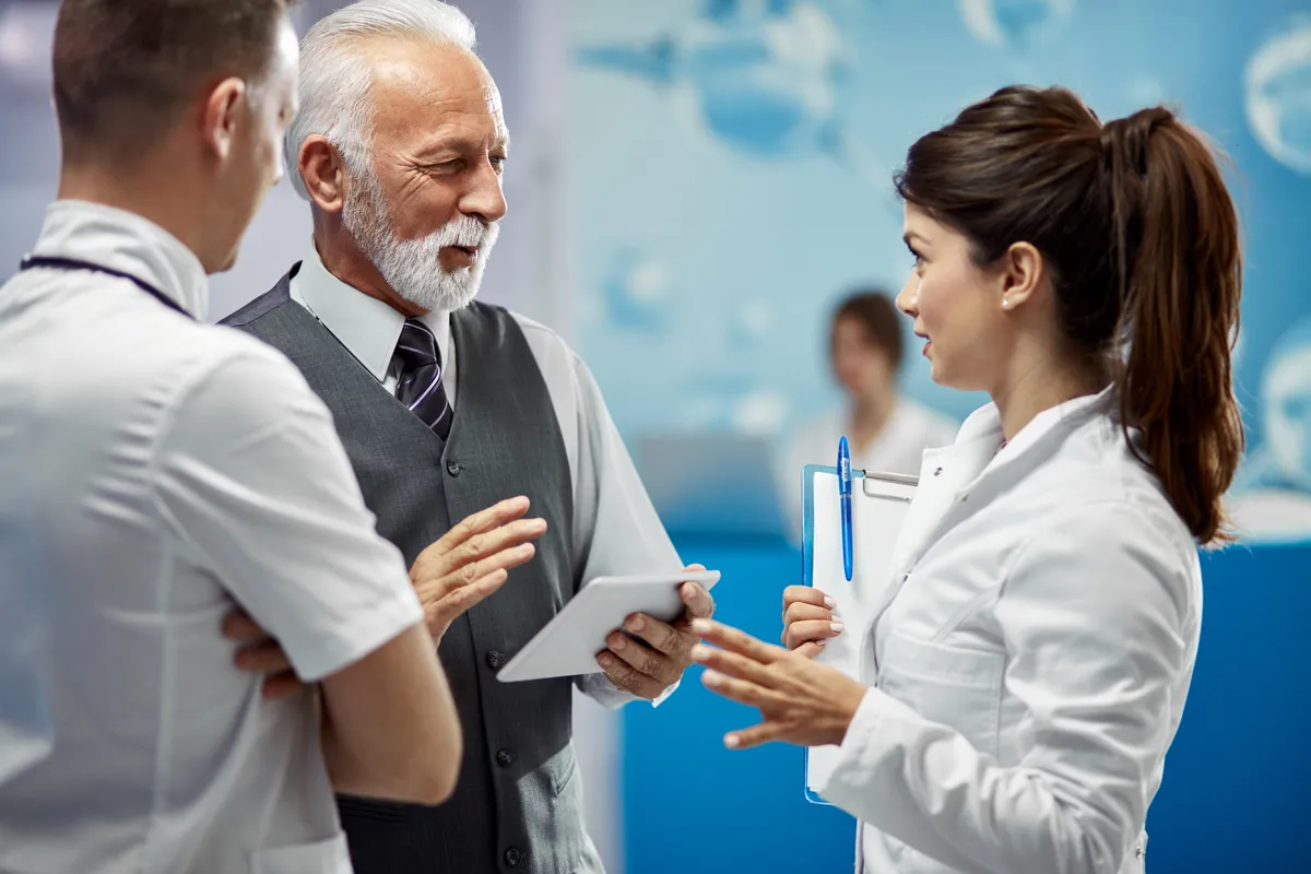 A friendly independent Medicare advisor sitting at a table discussing plan options with a senior couple.