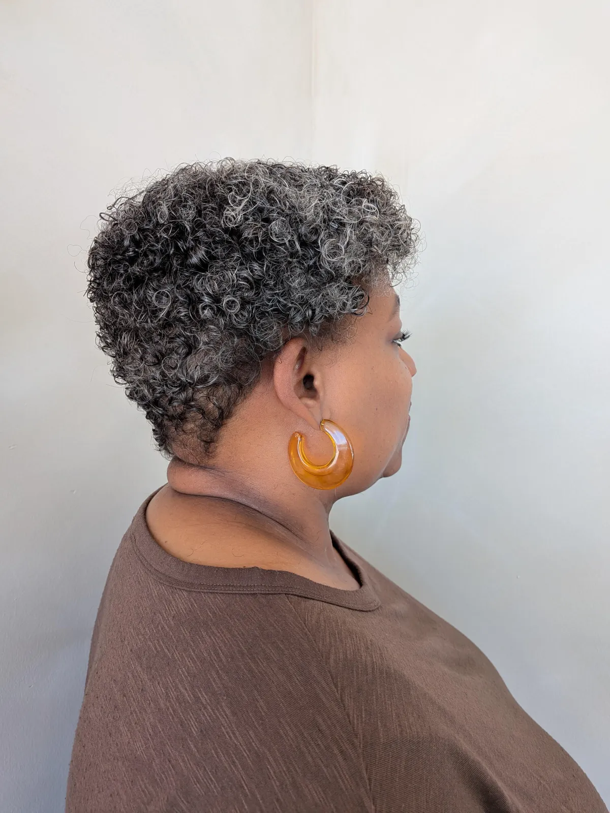Short curly pixie haircut with defined natural curls.