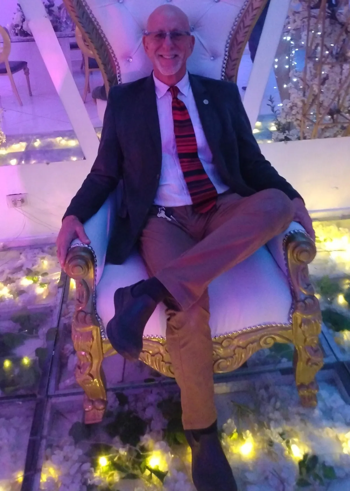 about John Gilletti: sitting down on king chair