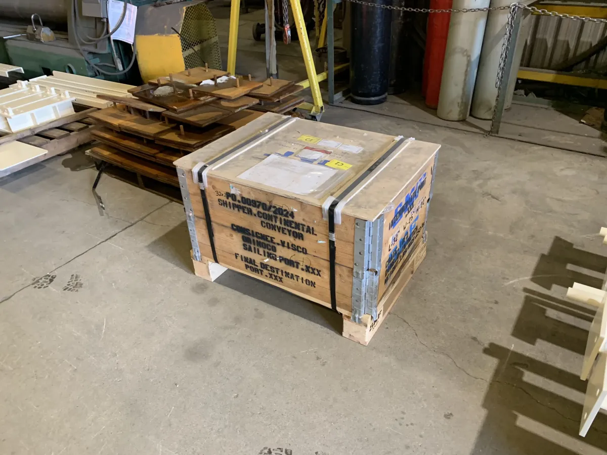 Crated and labelled industrial shipment on a wooden pallet inside a warehouse, prepared for transport