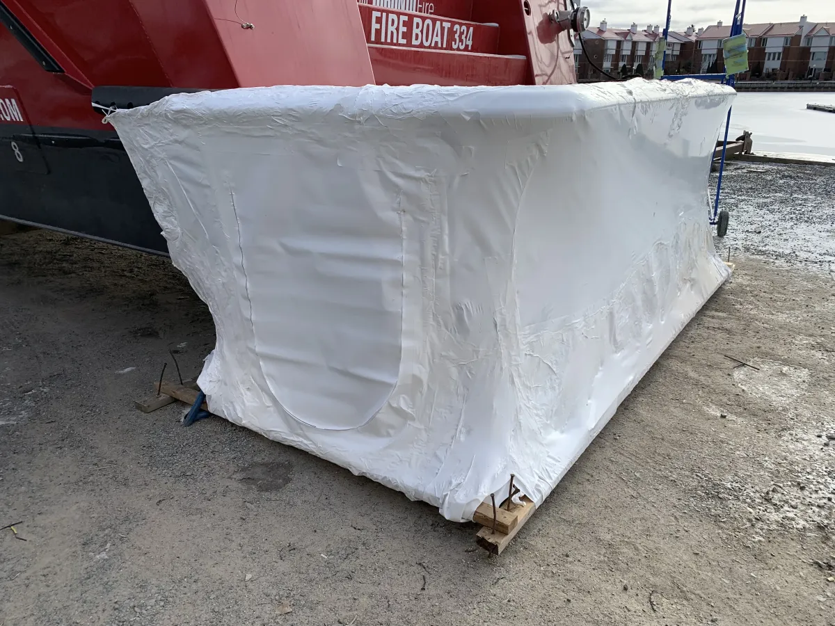 Flatbed truck load fully wrapped in form-fitting shrink film before transit