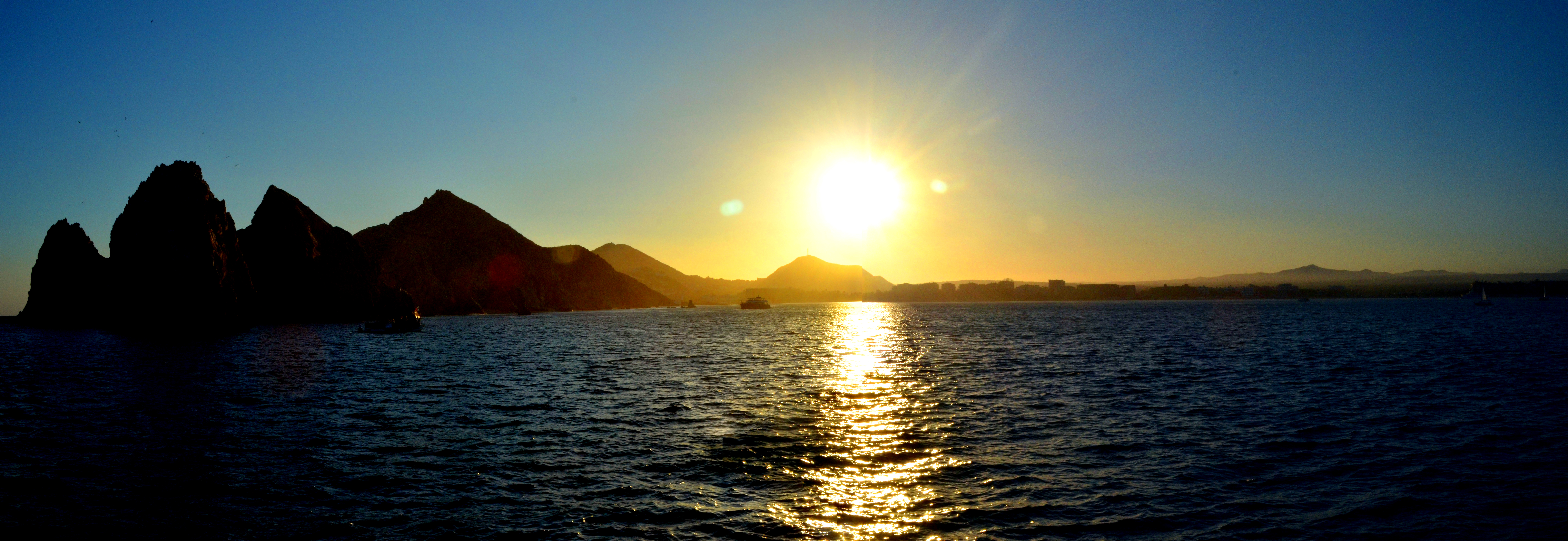 A breathtaking landscape photograph of a mountain range at sunrise, mist rolling over the peaks, vibrant colors in the sky, and a tranquil lake reflecting the scene, evoking peace and wonder.