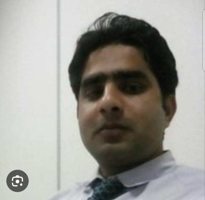 Portrait of Ali Ishrat, a middle-aged South Asian man in a tailored suit, standing confidently in front of a bookshelf filled with financial literature. The setting is warm and professional, with soft lighting highlighting his approachable demeanor.