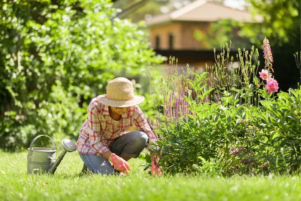 Woman gardening in a sunny garden, showing how outdoor activity can help stop overthinking and calm the mind