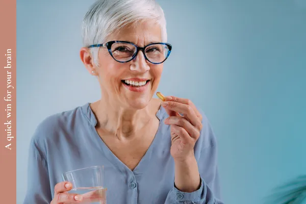 A woman taking an omega 3 supplement – building habits for long-term brain health