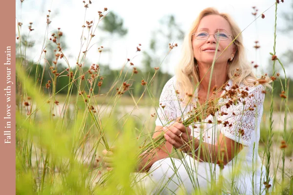 Middle-aged woman smiling and looking thoughtful, symbolising brain health and mental clarity in midlife.