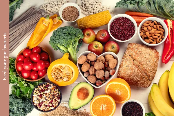 A colourful variety of plant-based foods including fruits, vegetables, legumes, whole grains, nuts, and seeds for supporting gut health and brain function.
