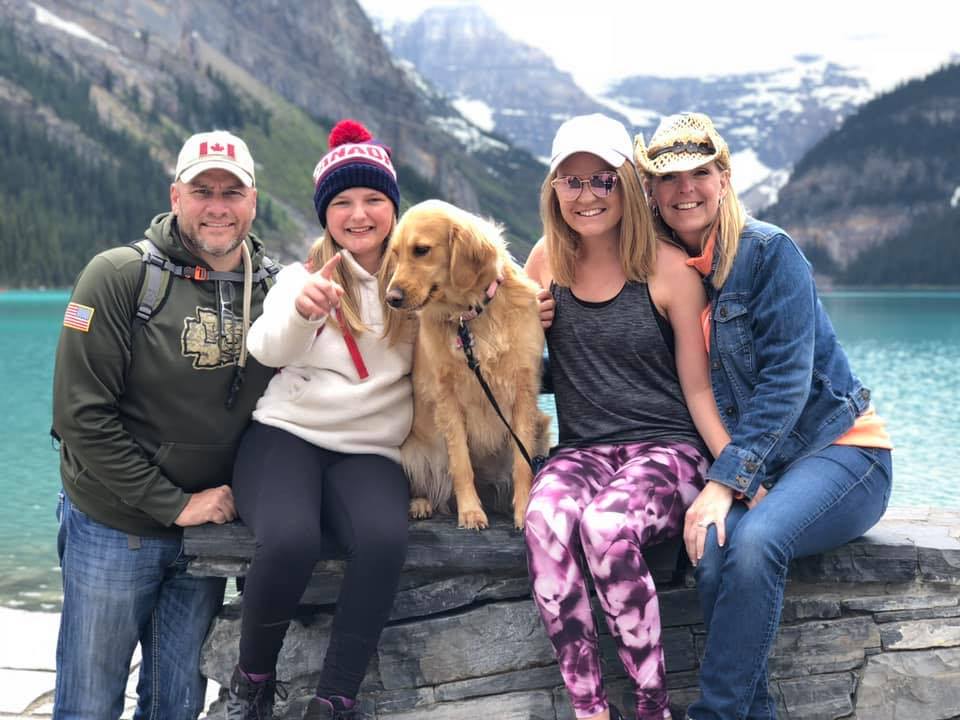A group portrait of the Rezalts Unlimited team in a modern workspace with navy and teal accents, smiling confidently.