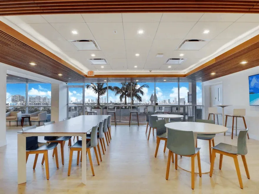 Bright modern kitchen remodel in Coral Springs featuring sleek matte cabinetry, granite island, and large windows.
