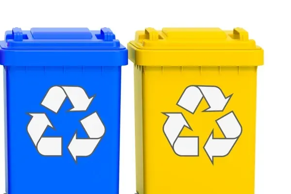 Blue and yellow recycling bins for sorting recyclable waste materials.