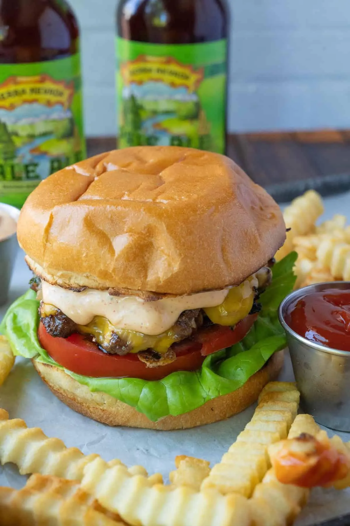 Cheeseburger with lettuce, tomato, and sauce served with crinkle-cut fries and ketchup. Informative, product-related.