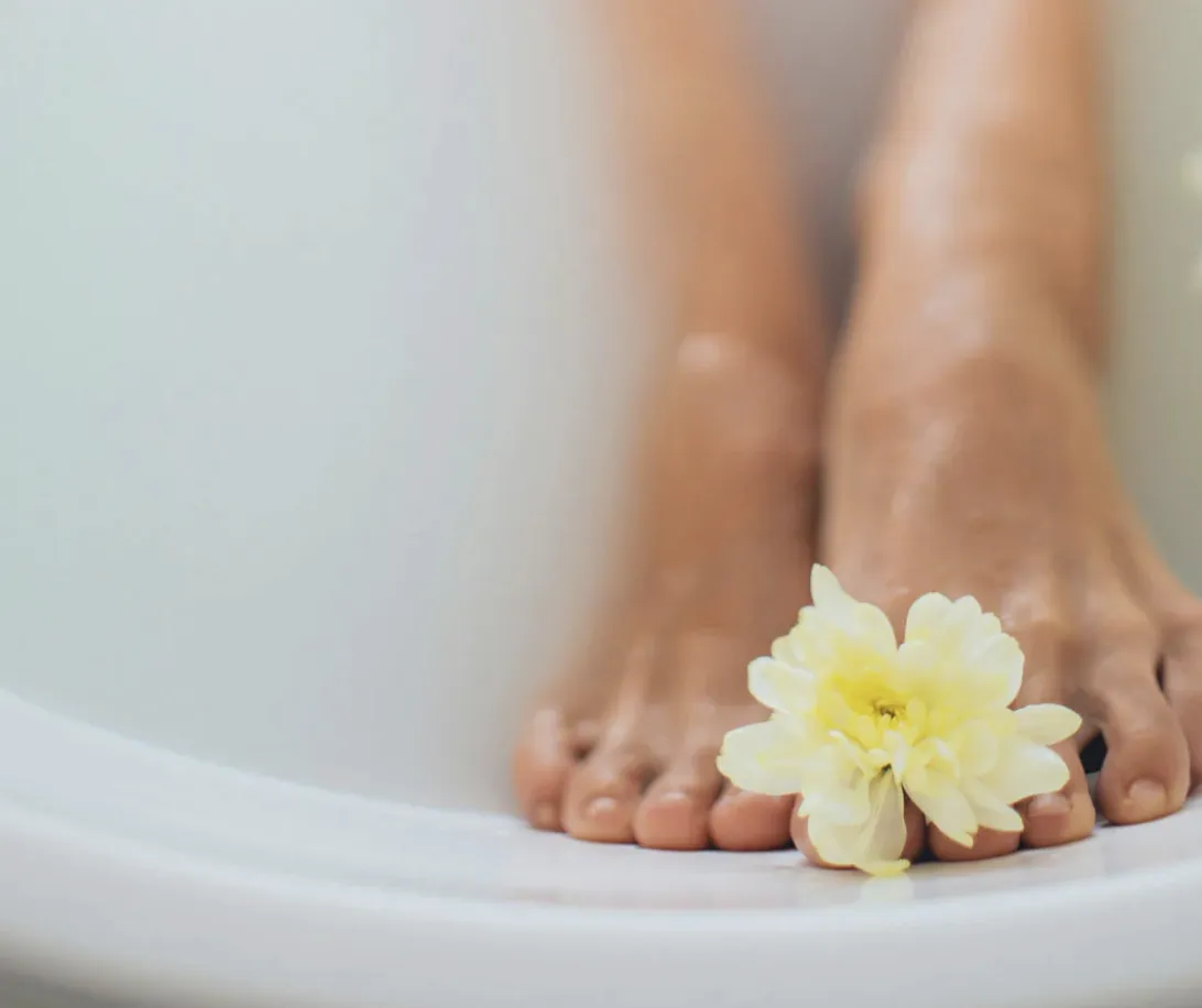 woman in black tank top and black pants sitting on green grass field during daytime