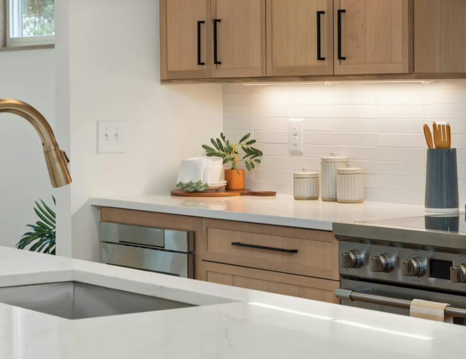 Luxury modern kitchen remodel with white cabinets quartz countertops hardwood flooring and stainless steel appliances installed by skilled remodeling contractors