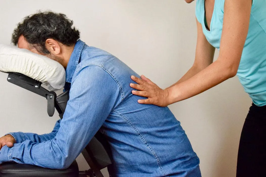 Un homme faisant un massage Amma assis