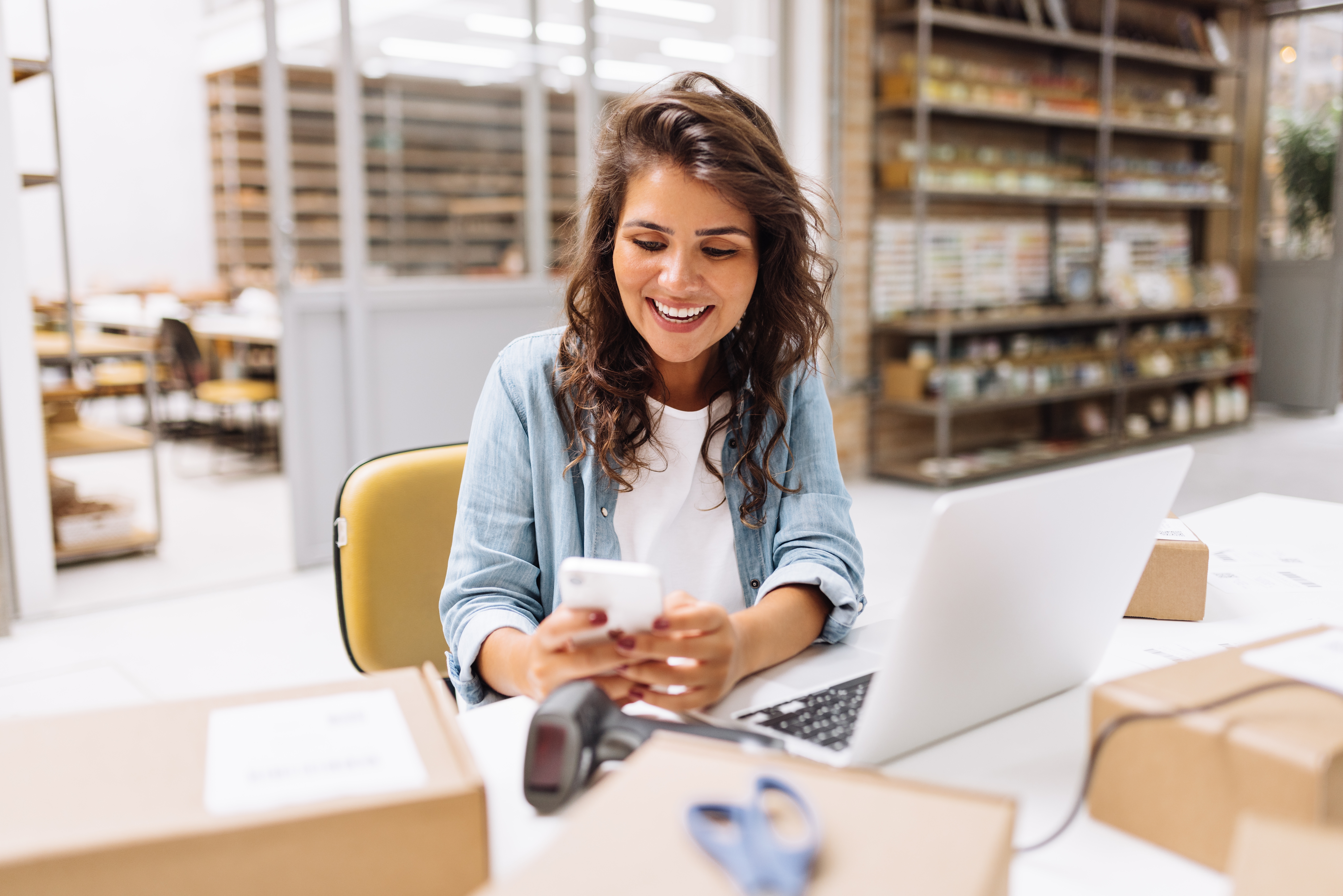 Small business owner managing orders on her laptop in her shop