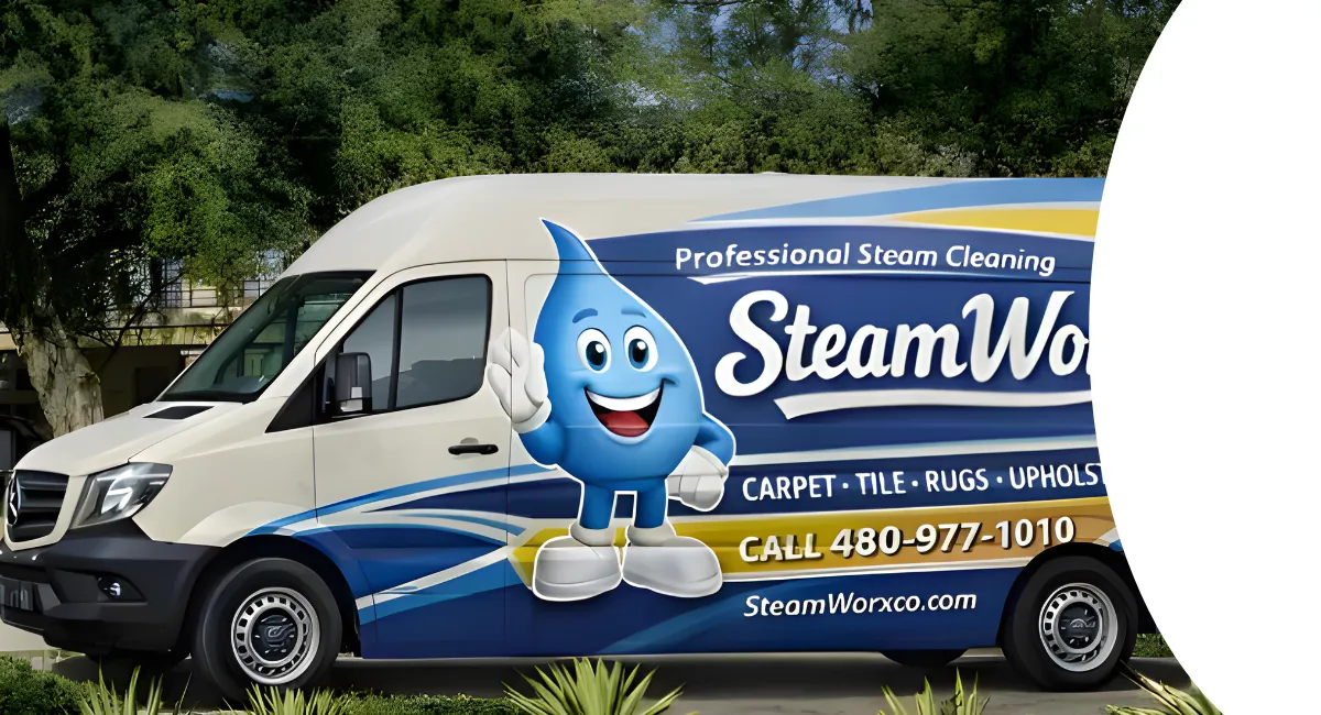 A white SteamWorx Mercedes van with blue and yellow branding parked on a street with trees in the background.