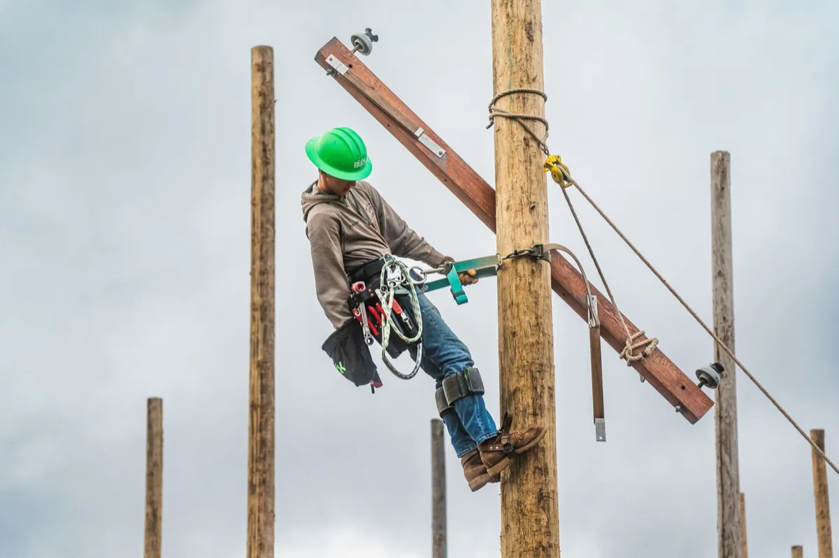 North Country line technician student climbing a utility pole