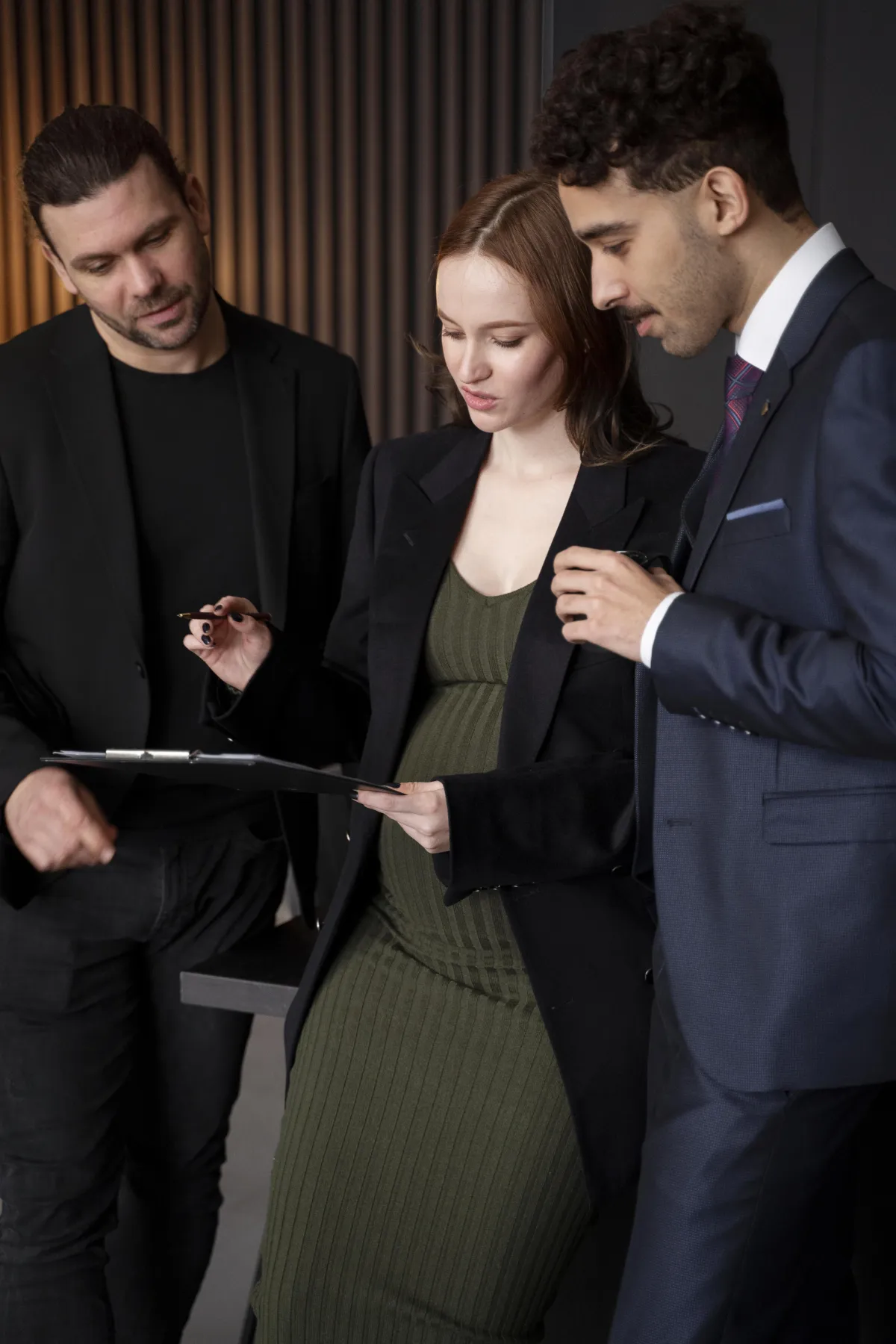 Three business professionals collaborating and reviewing documents during a strategy meeting.
