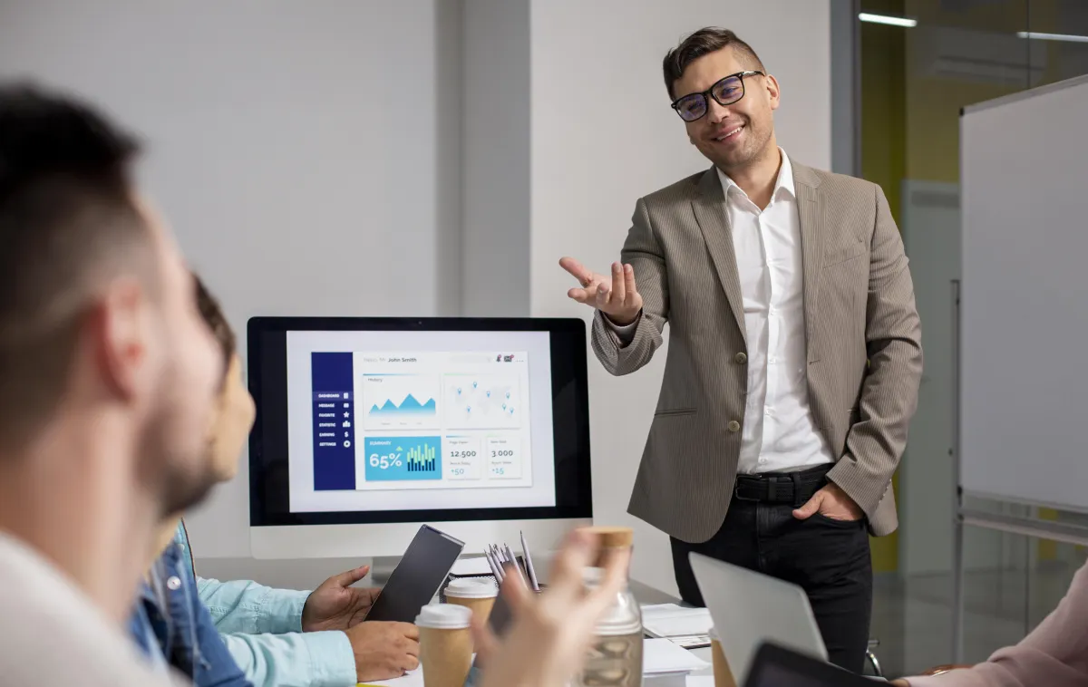 Business coach leading a strategy session with a team, discussing growth and performance metrics.