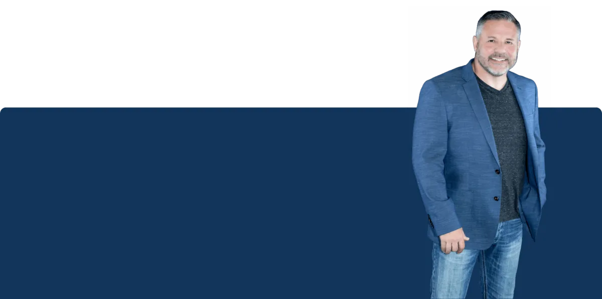 Joseph Drolshagen business coach and speaker standing confidently in a blue jacket, symbolizing leadership and growth.