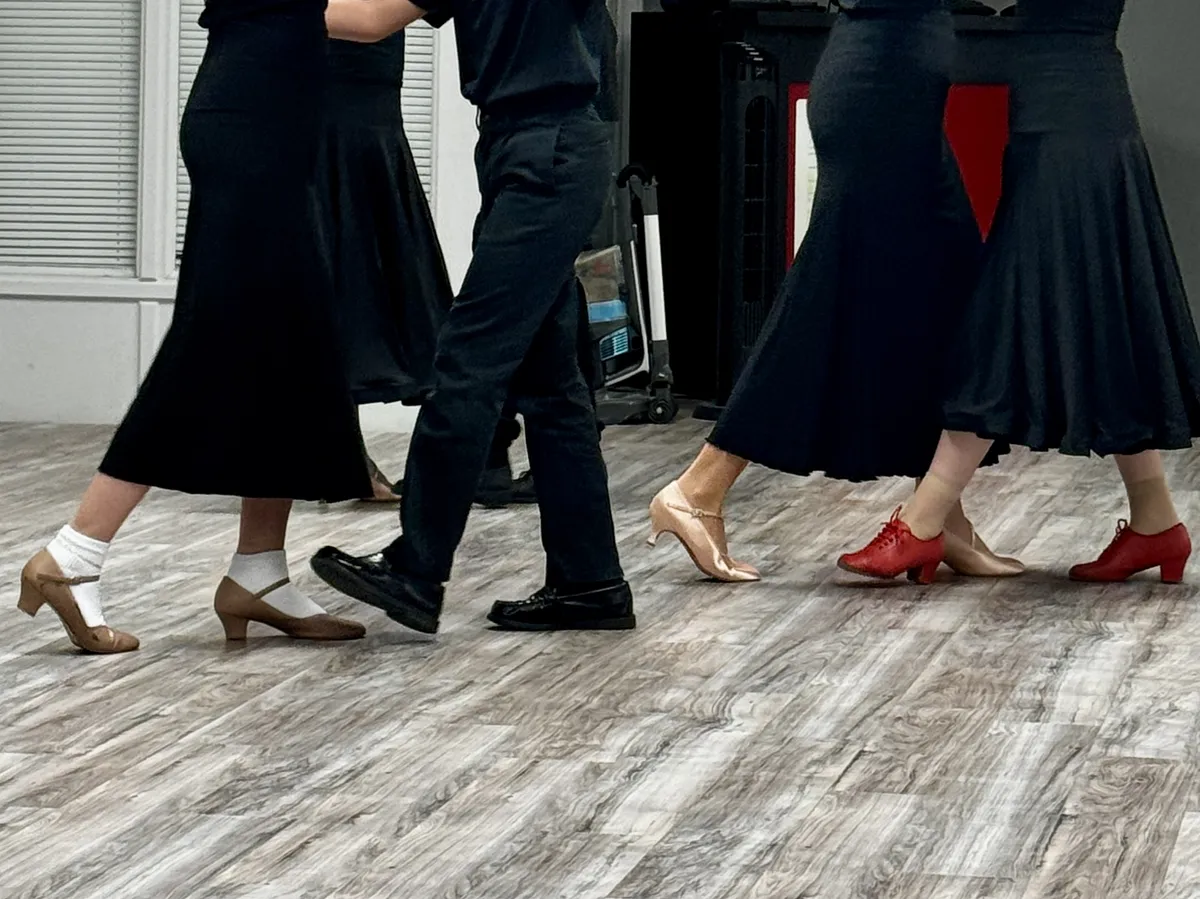 Youth Ballroom students practicing partner-dance footwork during class.