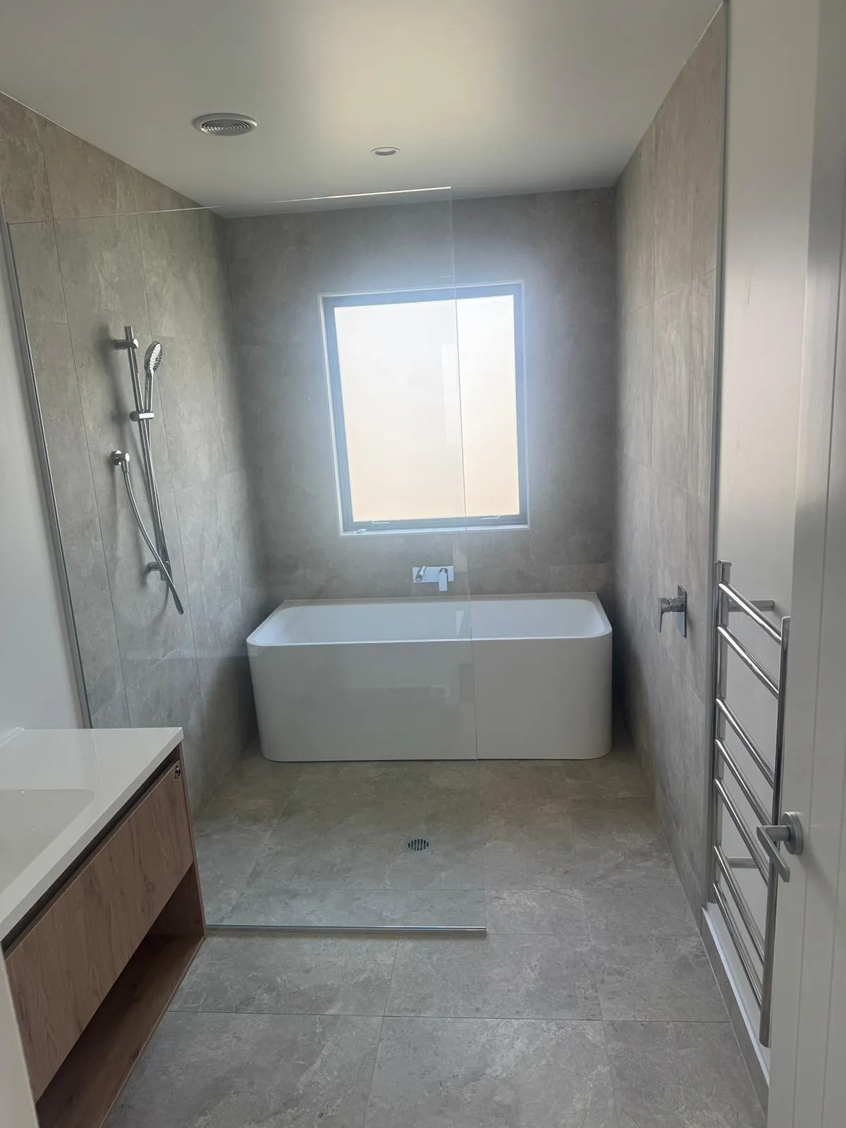 Completed full bathroom renovation featuring freestanding bath and floor to ceiling tiling by Remarkable Contracting in Napier