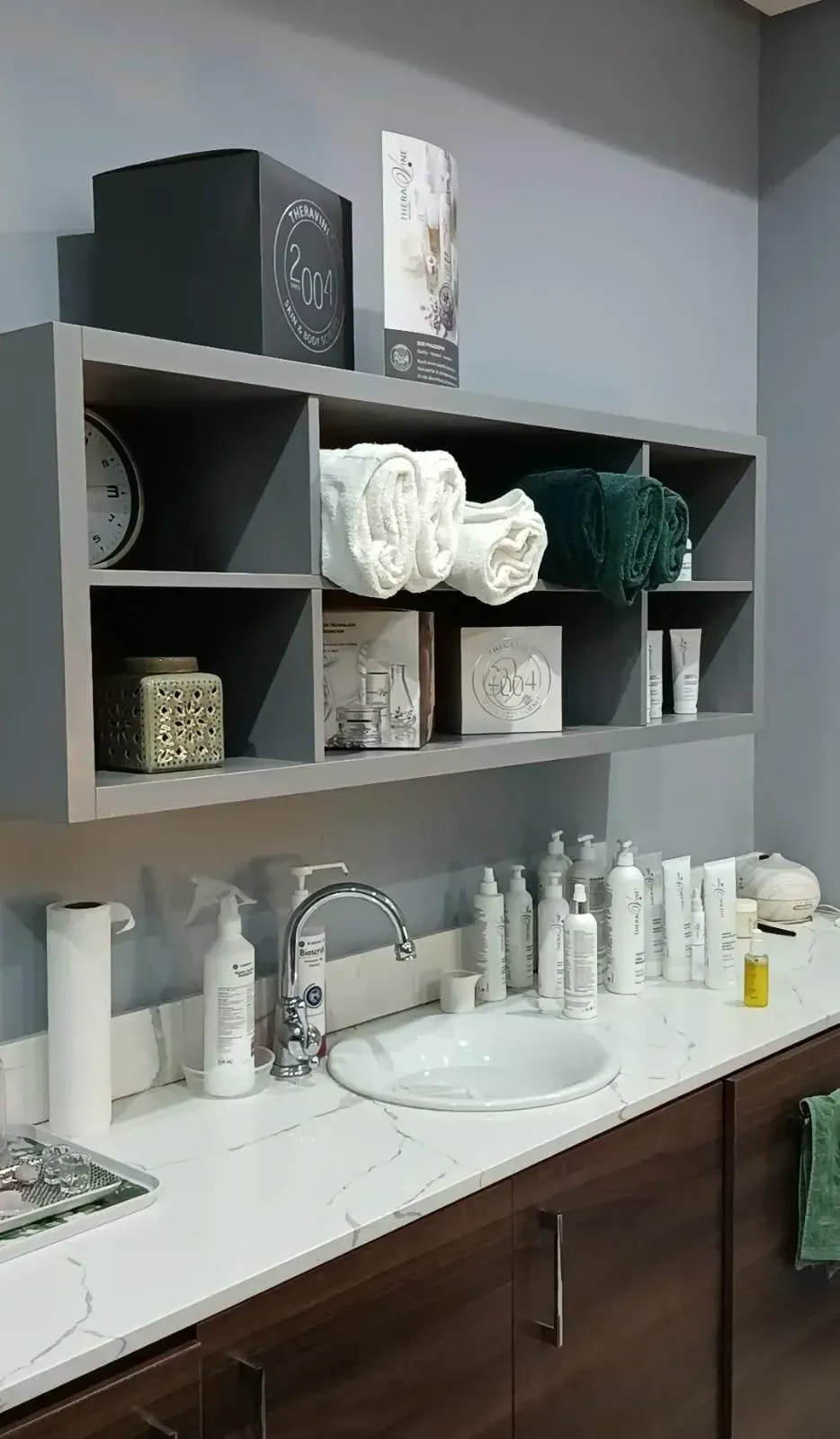 Minimal clinic interior with soft cream palette, seating area and natural sunlight; calming, editorial interior photograph.