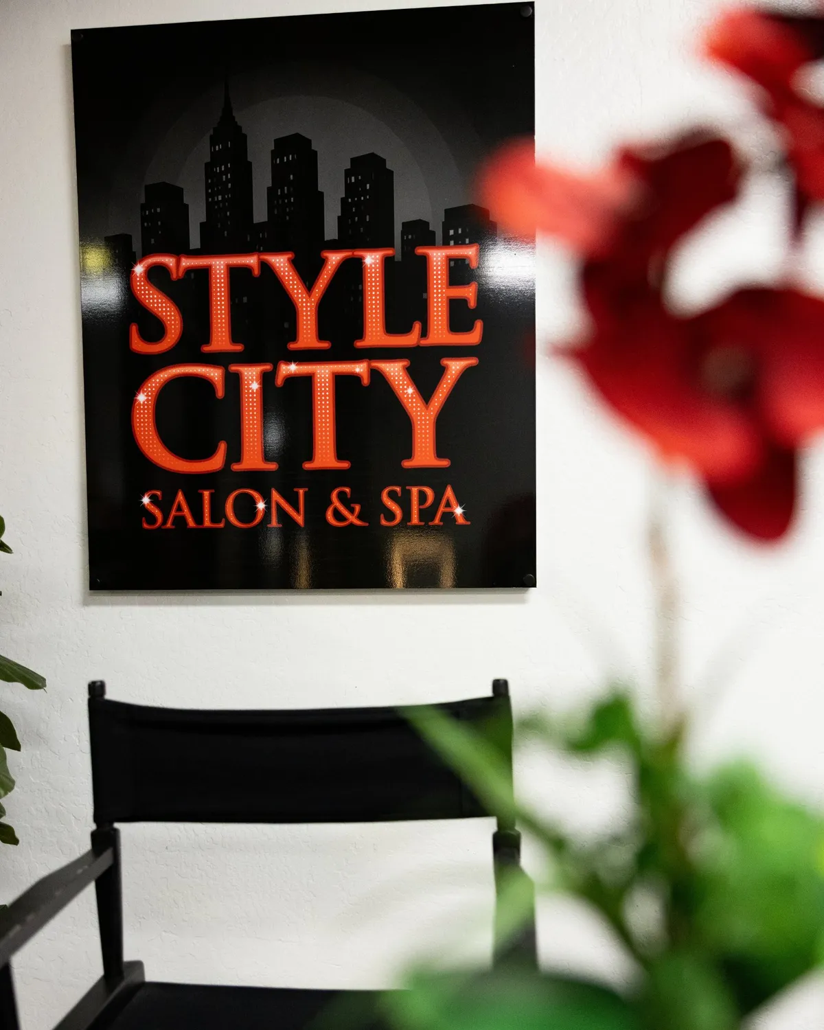 Style City Salon & Spa sign on the wall beside red flowers