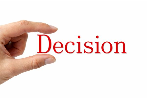 hand holding the word decision on a white background symbolising making a clear life choice and moving forward