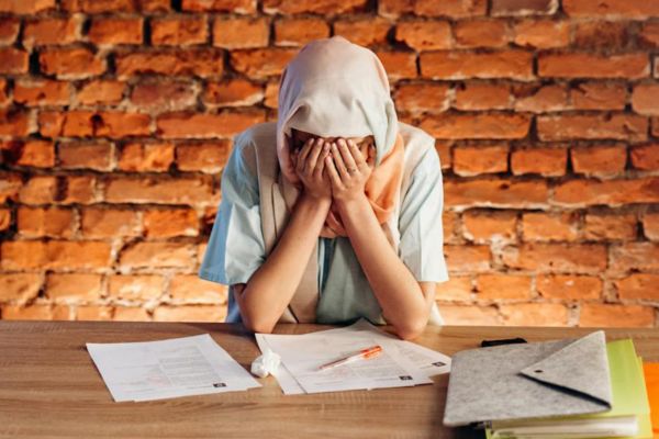 Woman with paperwork, looking overwhelmed