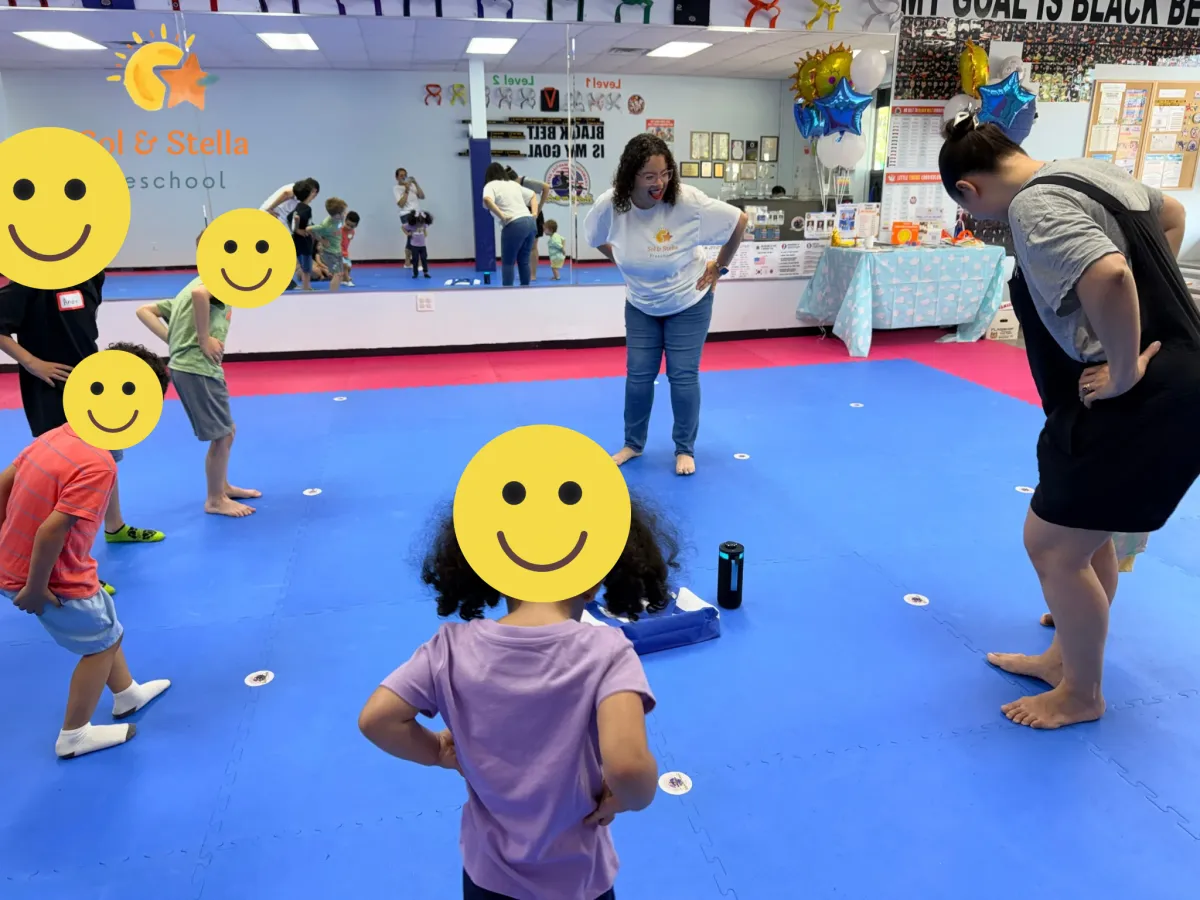 Girl stretches to the side while watching teacher on large screen TV