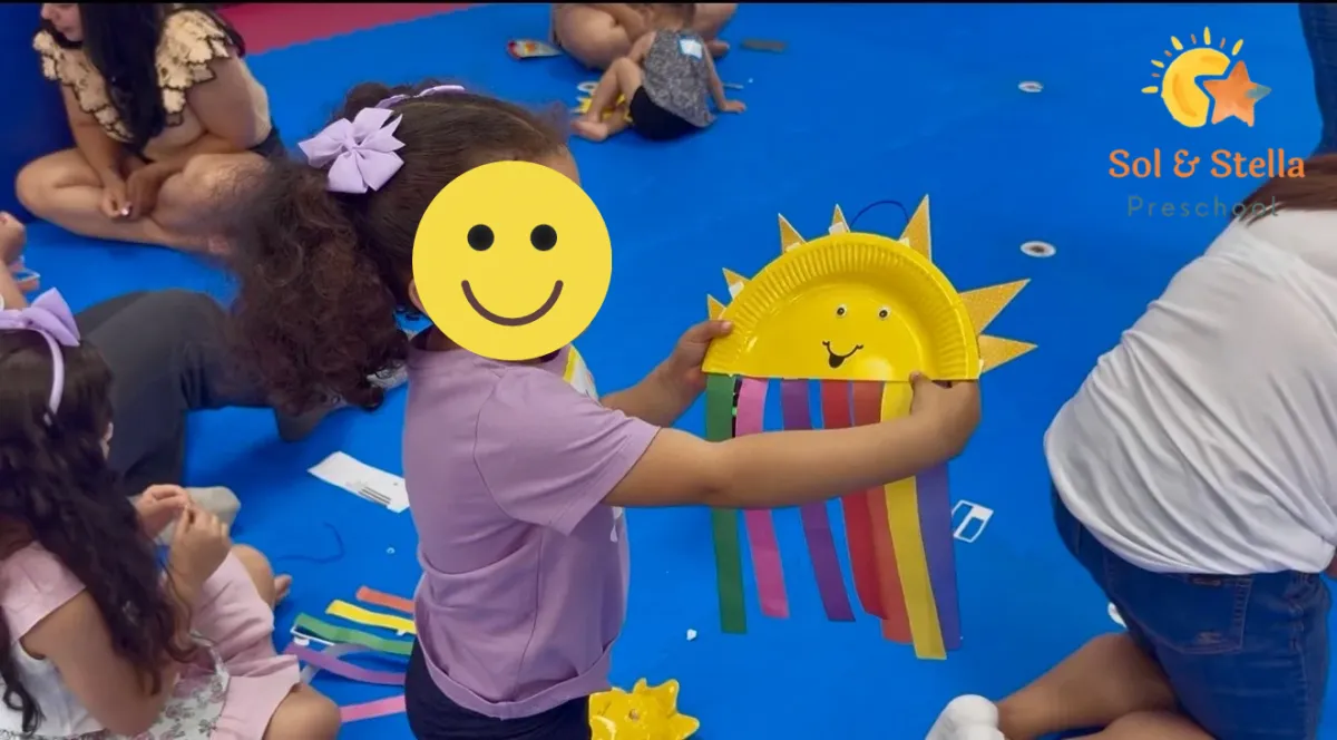 Child with headset smiles as he engages with laptop