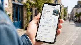 Smartphone affichant la fiche Google d’un restaurant avec bouton de réservation en ligne, consulté par un client dans la rue.