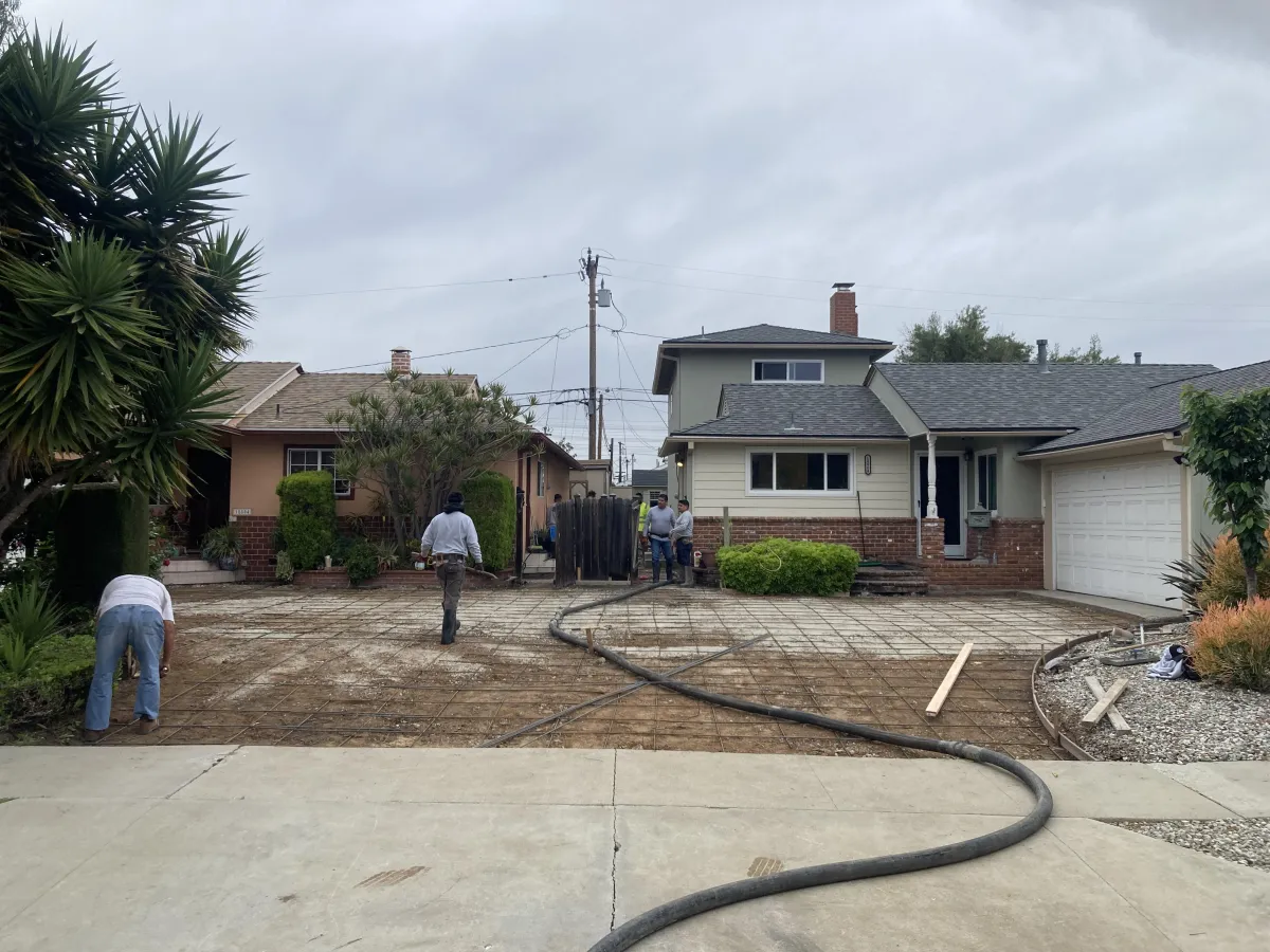 Image shows two homes that share a driveway that has old concrete ripped out and is being prepped for new concrete.