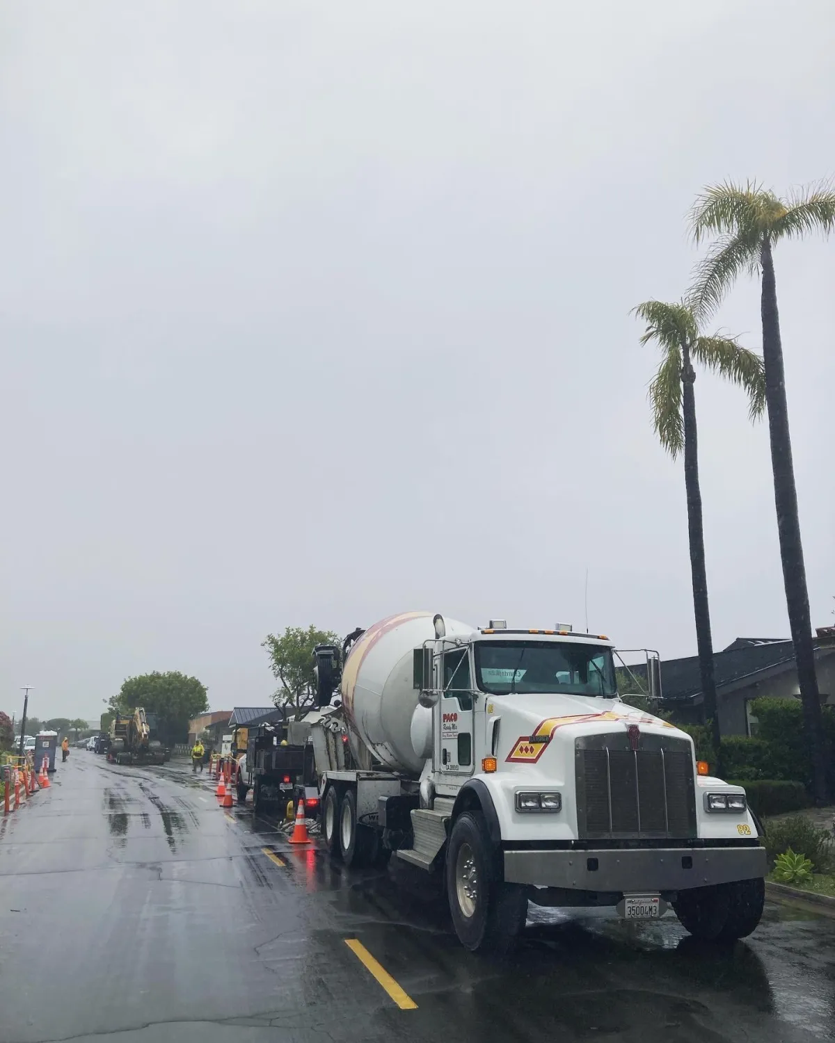 Image shows a Paco Ready Mix truck on a job in the rain while backed up to a pump.