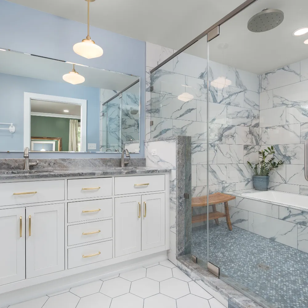 Luxury bathroom renovation featuring marble tile and freestanding tub